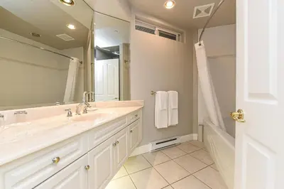 a bathroom with a sink and a large mirror at Crown Isle Resort & Golf Community in Courtenay