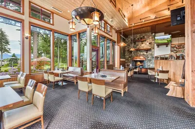 a restaurant with tables and chairs and a fireplace at Crown Isle Resort & Golf Community in Courtenay