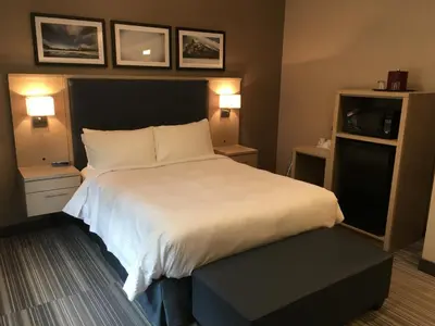 a bedroom with a large white bed and two lamps at Mountaineer Lodge in Lake Louise
