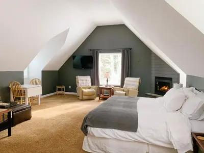 a bedroom with a large bed and a fireplace at The Inn at the Ninth Hole Bed & Breakfast in Salmon Arm