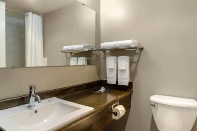 a bathroom with a sink and a toilet and a mirror at Motel 6 Merritt, BC in Merritt