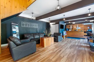 a living room with leather furniture and a table at Stoke Hotel SureStay Collection by Best Western in Revelstoke