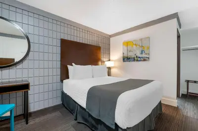 a hotel room with a large bed and a mirror at Stoke Hotel SureStay Collection by Best Western in Revelstoke