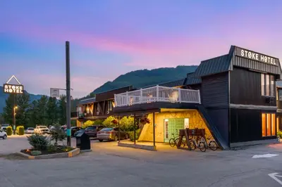 a building with bikes parked in a parking lot at Stoke Hotel SureStay Collection by Best Western in Revelstoke