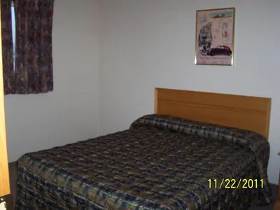 a bedroom with a bed and a picture on the wall at Model A Inn in Cranbrook