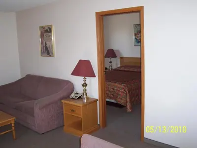 a room with a couch and a bed and a mirror at Model A Inn in Cranbrook