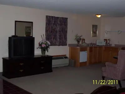 a living room with a television and a kitchen at Model A Inn in Cranbrook
