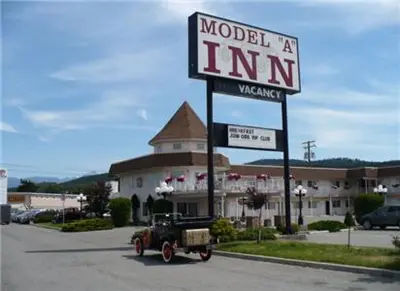 an old truck parked in front of a motel sign at Model A Inn in Cranbrook