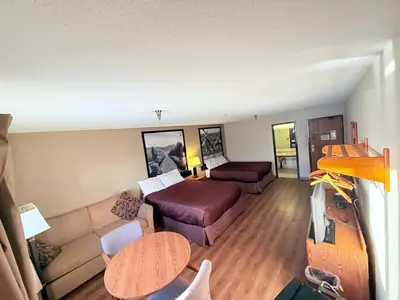a living room with a couch and a bed at Super 8 by Wyndham Salmon Arm in Salmon Arm
