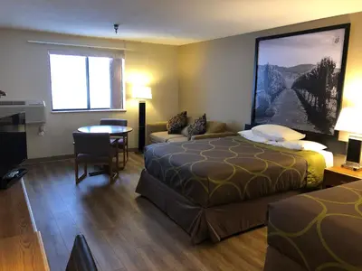 a hotel room with two beds and a table at Super 8 by Wyndham Salmon Arm in Salmon Arm