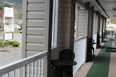 a porch of a house with chairs and a window at Monashee Lodge in Revelstoke