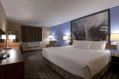 a hotel room with a bed and a desk at Super 8 by Wyndham Kamloops On The Hill in Kamloops