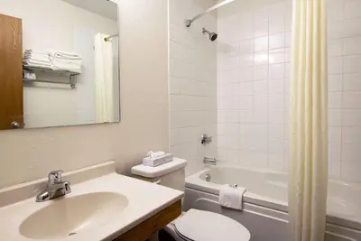 a bathroom with a sink and a toilet and a tub at Super 8 by Wyndham Kamloops On The Hill in Kamloops