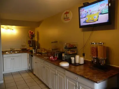 a kitchen with a counter with a tv on the wall at Super 8 by Wyndham Kamloops East in Kamloops