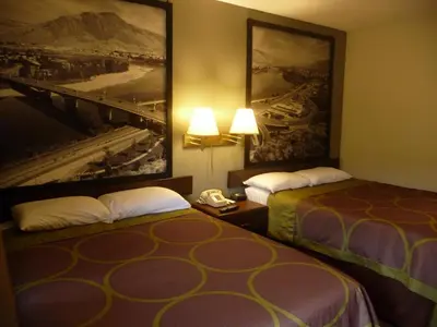 a hotel room with two beds with a picture on the wall at Super 8 by Wyndham Kamloops East in Kamloops