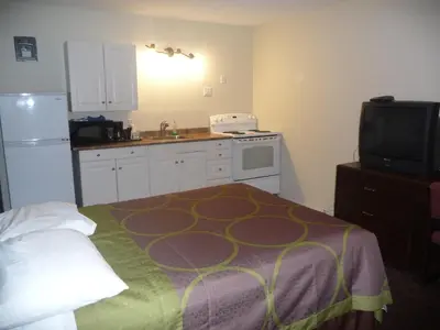 a small kitchen with a bed and a tv at Super 8 by Wyndham Kamloops East in Kamloops