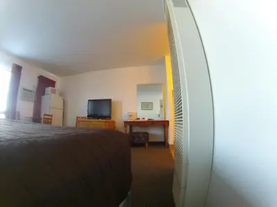 a bedroom with a bed and a desk and a television at Rycroft Hotel in Rycroft