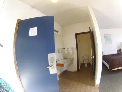 a room with a bathroom with a bed and a sink at Rycroft Hotel in Rycroft
