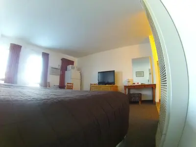 a bedroom with a bed and a mirror at Rycroft Hotel in Rycroft