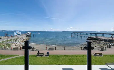 a view of a pier and the ocean with benches at Sidney Waterfront Inn & Suites in Sidney