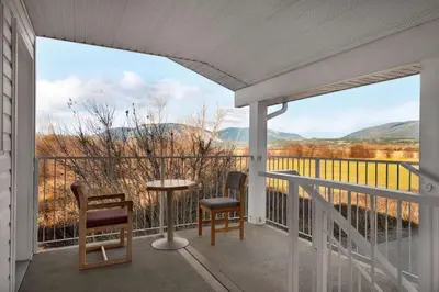 a balcony with a table and chairs and a view at Travelodge by Wyndham Salmon Arm BC in Salmon Arm