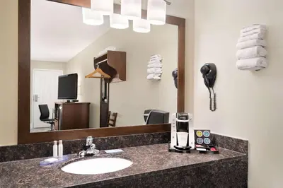 a bathroom with a sink and a mirror at Travelodge by Wyndham Salmon Arm BC in Salmon Arm