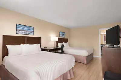 a hotel room with two beds and a flat screen tv at Travelodge by Wyndham Salmon Arm BC in Salmon Arm