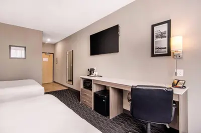 a hotel room with a desk and a tv at Comfort Inn & Suites in North Battleford