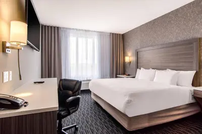 a hotel room with a large bed and a desk at Comfort Inn & Suites in North Battleford