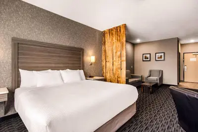 a hotel room with a large bed and a chair at Comfort Inn & Suites in North Battleford