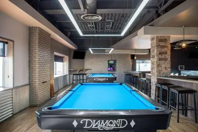 a pool room with a bar and a pool table at Days Inn & Conference Centre by Wyndham Camrose Norsemen in Camrose