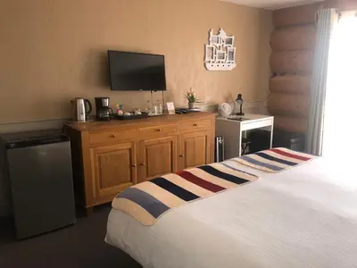 a hotel room with a bed and a television at Cariboo Log Guest House in Lac La Hache