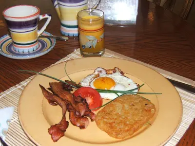 a plate of breakfast food with eggs bacon and toast at Baergnaescht B&B in Osoyoos