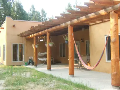 a patio with a hammock under a pergola at Baergnaescht B&B in Osoyoos