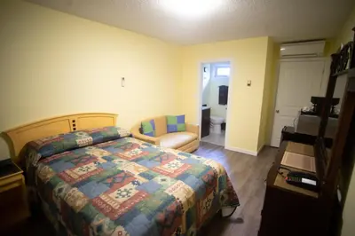 a bedroom with a bed and a chair in it at Stardust Motel in Camrose