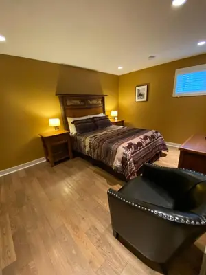 a bedroom with a bed and a couch and a chair at Fitzhugh House Guest Accomodation in Jasper