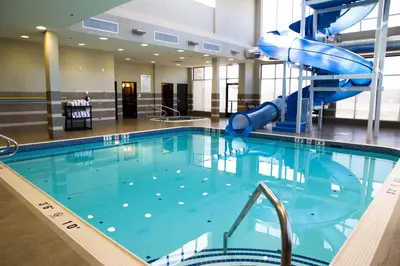 a large swimming pool with a slide in a building at Holiday Inn Hotel & Suites Red Deer by IHG in Red Deer