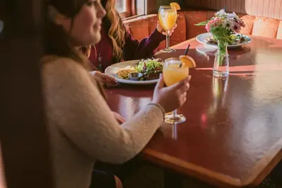 two women sitting at a table with a plate of food at Salt Spring Inn in Ganges
