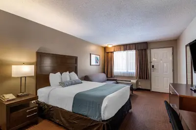 a hotel room with a large bed and a desk at SureStay Plus Hotel by Best Western Salmon Arm in Salmon Arm