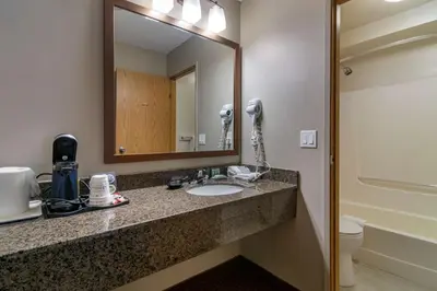 a bathroom with a sink and a mirror at SureStay Plus Hotel by Best Western Salmon Arm in Salmon Arm