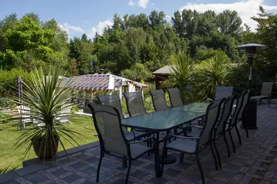 a glass table and chairs on a patio at Genelle House B&B Guest House in Genelle
