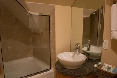 a bathroom with a sink and a tub and a shower at Genelle House B&B Guest House in Genelle