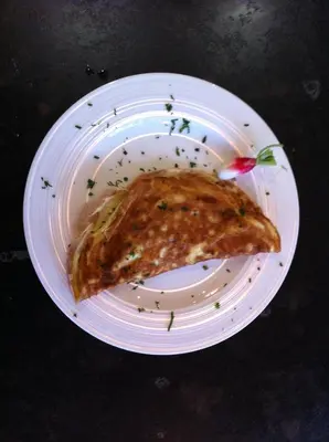 a white plate with a slice of pizza on it at Genelle House B&B Guest House in Genelle