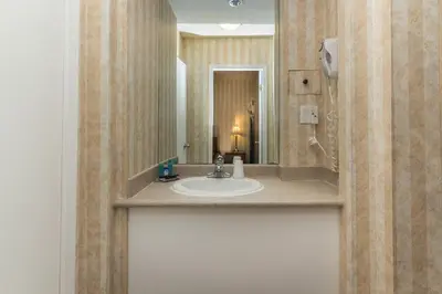 a bathroom with a sink and a mirror at Canadas Best Value Inn Chinook Station in Calgary