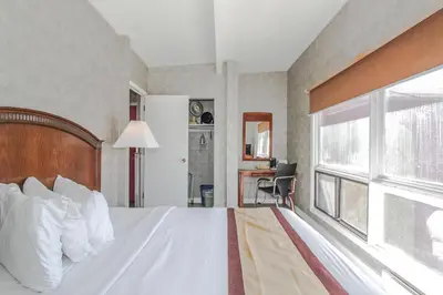 a bedroom with a white bed with a window at Canadas Best Value Inn Chinook Station in Calgary