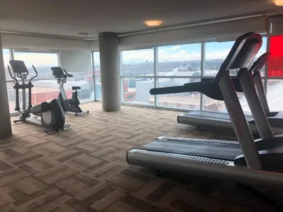 a gym with treadmills and exercise equipment in a building at SAIT Residence & Conference Centre - Calgary in Calgary