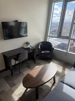 a living room with a desk and a chair at SAIT Residence & Conference Centre - Calgary in Calgary