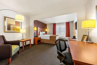 a hotel room with a bed and a desk at Wingate by Wyndham Calgary South in Calgary