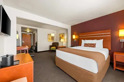 a hotel room with a large bed and a television at Wingate by Wyndham Calgary South in Calgary