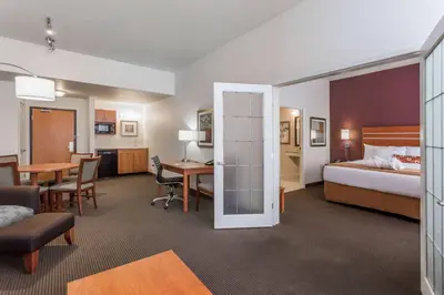a hotel room with a bed and a desk and a bedroom at Wingate by Wyndham Calgary South in Calgary